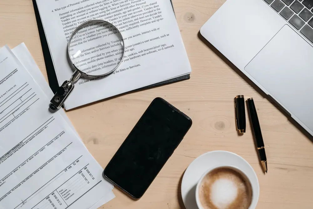 Documents, a laptop and magnifying glass representing information retrieval and enterprise knowledge search